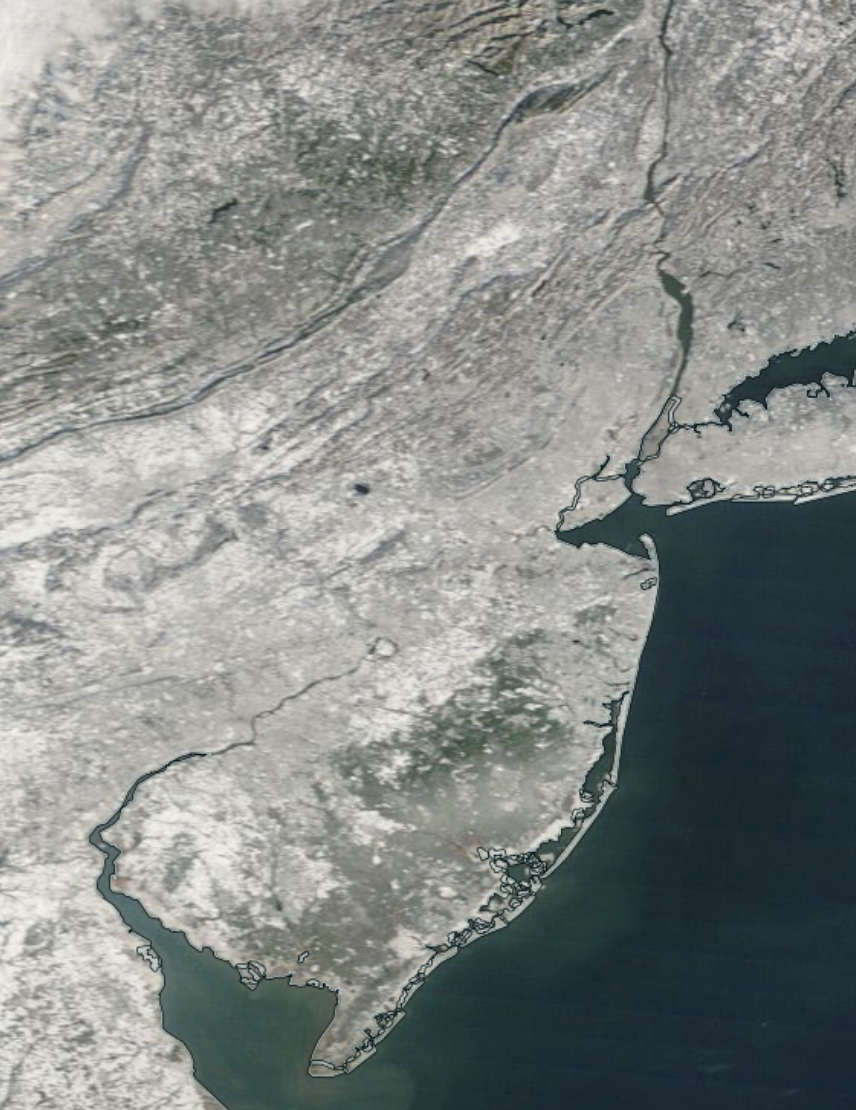Figure 7. MODIS visible image of snow-covered New Jersey and surrounding states on the morning of December 16th. Darker areas are heavily forested, thus much of the snow “hidden” by the overlying tree cover, especially in the southern Pinelands. The small dark “dot” in west central NJ is ice-free Round Valley Reservoir in Hunterdon County (NASA). MODIS visible image of snow-covered New Jersey and surrounding states on the morning of December 16th.